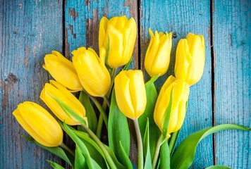 bouquet of yellow tulips on a blue rustic background