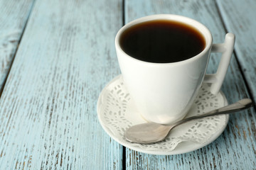 Cup of coffee with spoon on color rustic wooden background