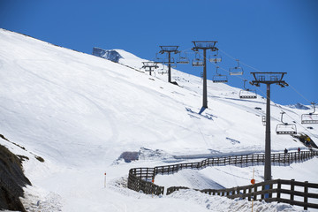 Fototapeta na wymiar Winter mountains panorama with ski lifts on a cloudy day
