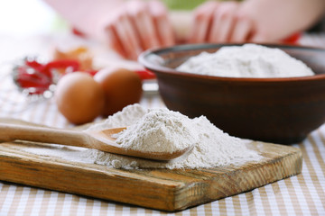 Young woman prepares dough on table close up