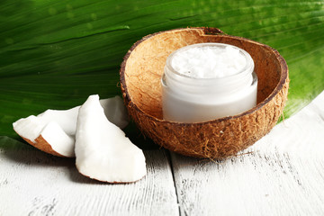 Fresh coconut oil in glass bottle and green leaf