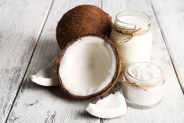Fresh coconut oil in glassware on color wooden table background
