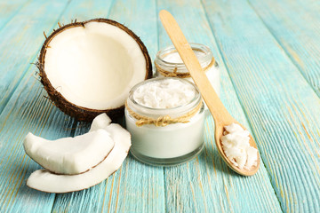 Fototapeta na wymiar Fresh coconut oil in glassware and wooden spoon