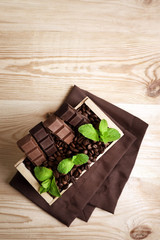 Still life with set of chocolate in wooden box of coffee grains