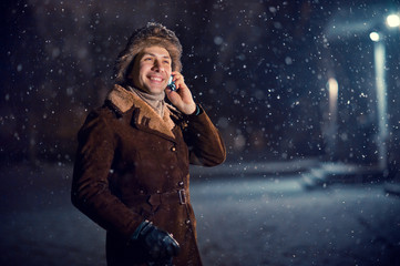 man talking on the phone on a winter night