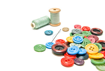 plastic buttons and spools of thread on white