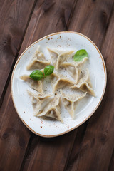 Khinkali with black pepper over dark wooden background