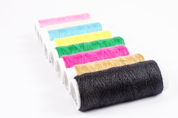 multicolor sewing threads on white background,