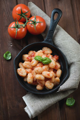 Frying pan with italian gnocchi in tomato sauce, high angle view