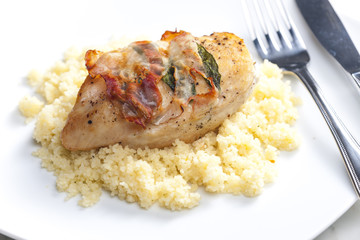 chicken meat on sage baked with bacon and served with couscous