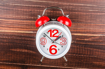 Alarm clock on wooden board background