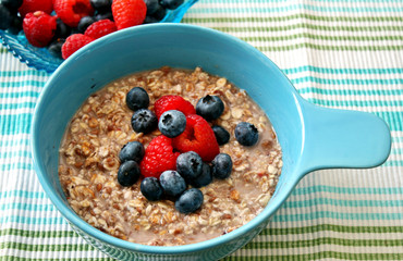 A bowl of oatmeal topped with blueberries and raspberries