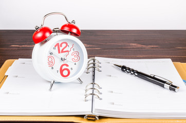 Alarm clock on wooden board background