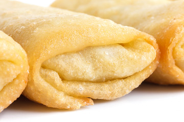Fried chinese spring rolls on white surface.