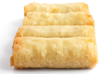 Fried chinese spring rolls on white surface.
