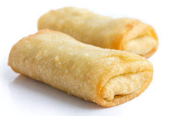 Fried chinese spring rolls on white surface.