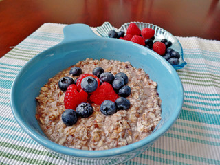 A bowl of oatmeal topped with blueberries and raspberries