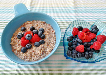 A bowl of oatmeal topped with blueberries and raspberries