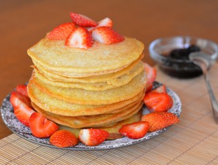 Stack of sweet pancakes with strawberry and icing sugar
