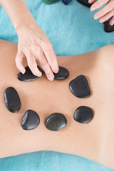 Adult woman having hot stone massage