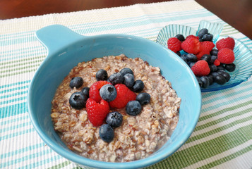 A bowl of oatmeal topped with blueberries and raspberries