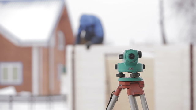 Land surveyor total station against the background of a wooden