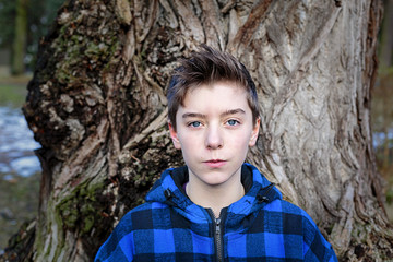 portrait of a teenage boy with blue plaid lumberjack jacket