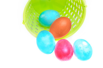 Several Easter eggs in a basket on white