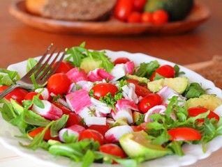 Mixed vegetable salad with crab sticks and avocado