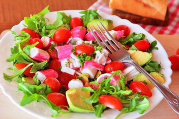 Mixed vegetable salad with crab sticks and avocado