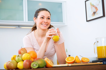 Beautiful woman with orange Juice in the kitchen