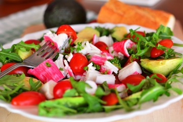 Mixed vegetable salad with crab sticks and avocado