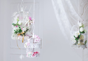 White decorative cage with beautiful flowers, suspension cells
