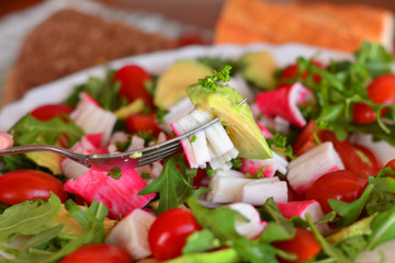 Mixed vegetable salad with crab sticks and avocado