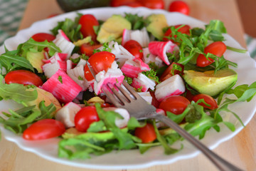 Mixed vegetable salad with crab sticks and avocado