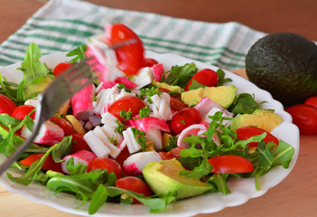 Mixed vegetable salad with crab sticks and avocado