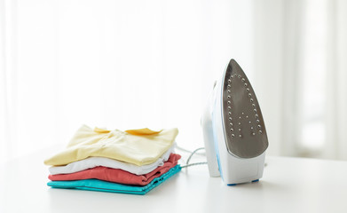 close up of iron and clothes on table at home