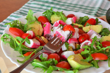 Mixed vegetable salad with crab sticks and avocado