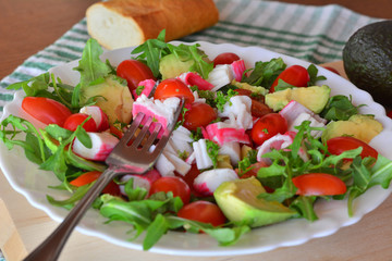 Mixed vegetable salad with crab sticks and avocado