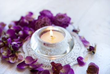 Candle in the dried rose petals . aromatherapy