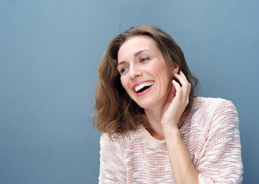 Cheerful woman laughing with hand in hair