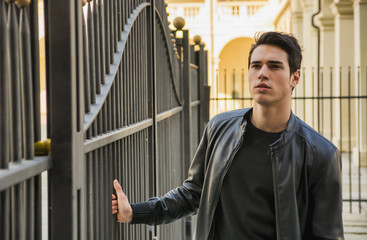 Handsome young man outside historical building in European city