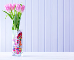Beautiful pink tulips with sweets in vase