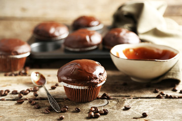 Tasty homemade chocolate muffins on wooden table