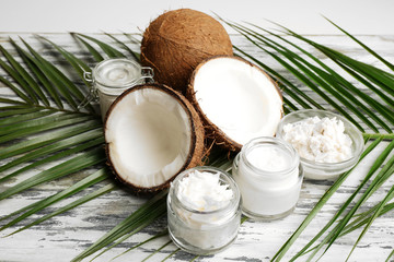 Coconut with jars of coconut oil and cosmetic cream