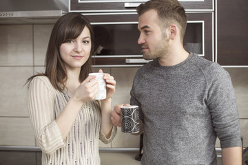 Cheerful couple drinking coffee in kitchen