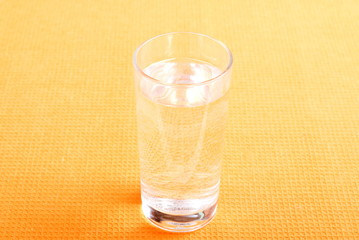 water in a glass and a napkin on the board