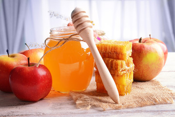 Delicious honey with apple on table on light background