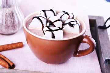 Cup of cocoa with marshmallows on tray with napkin, closeup
