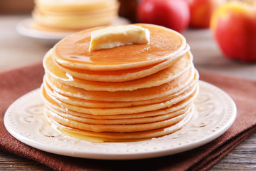 Delicious pancakes with honey on plate on table close-up